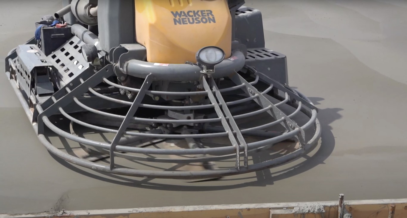 Professional concrete power trowel machine finishing fresh concrete surface for smooth durable finish